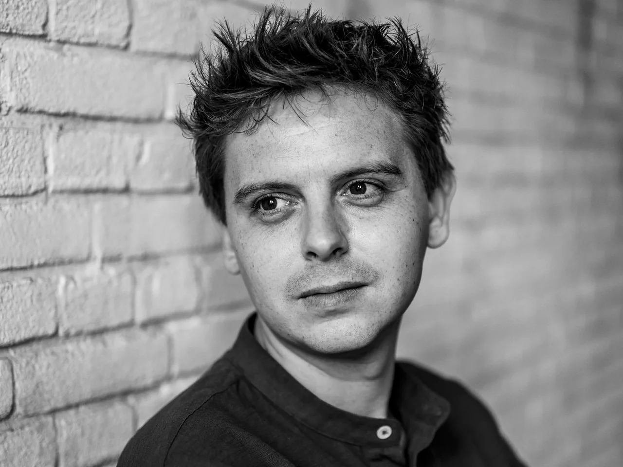 Joost van der Zwan, photographed against a painted brick wall